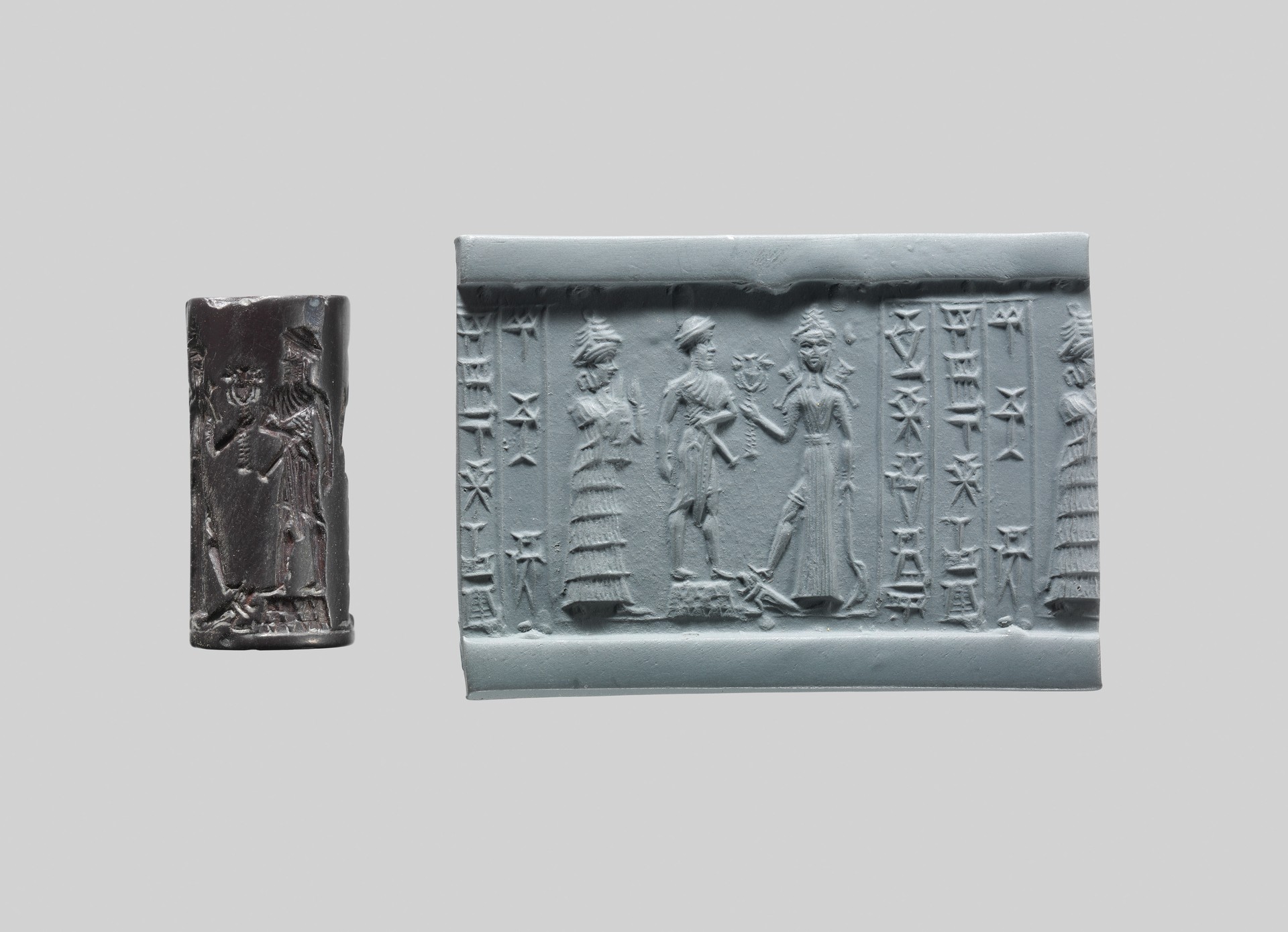 Dark cylinder seal beside its rolled impression, showing armed Ishtar standing on a lion-headed eagle with two approaching figures.