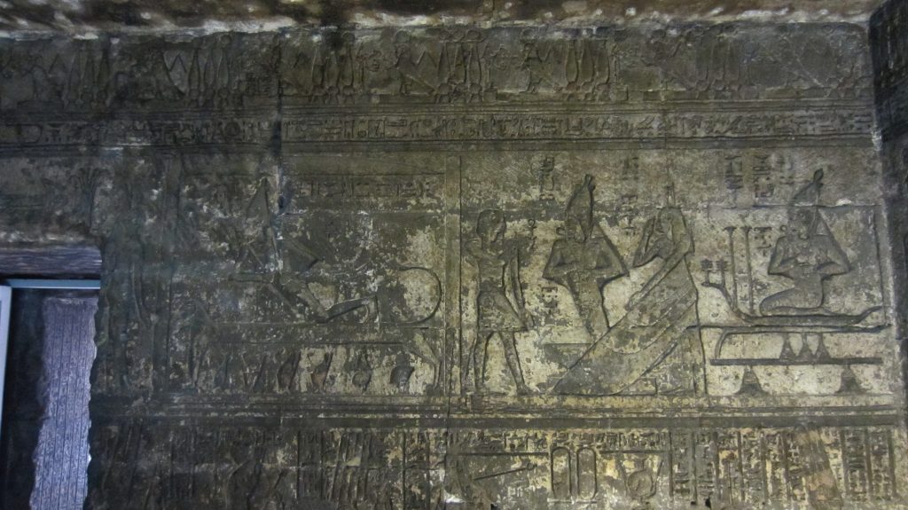 Stone relief with scenes of Osiris rising from a bier and standing beneath the outstretched wings of Isis.